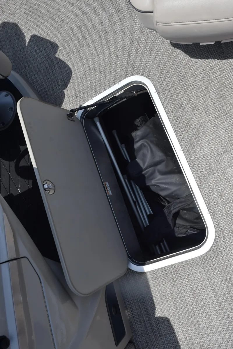 Slide: The Image of 2022 Barletta L25UC storage compartment with open lid, revealing interior space on a textured floor. - 18
