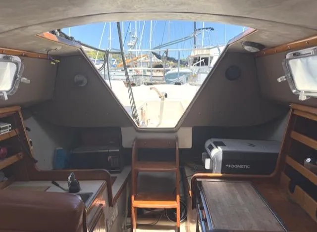Slide: The Image of Interior view of a 1979 Lancer Sloop sailboat with marina background. - 12