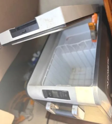 Slide: The Image of Open portable cooler inside a 1979 Lancer Sloop boat, showing interior storage space. - 18