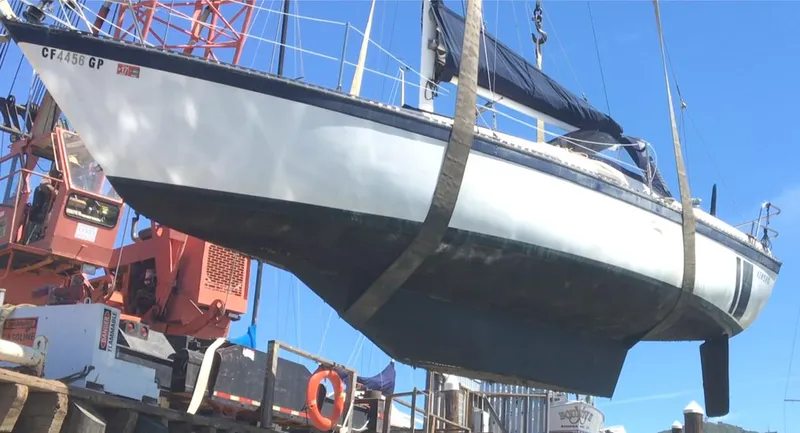 Slide: The Image of 1979 Lancer Sloop sailboat being lifted by crane at a dock. - 3
