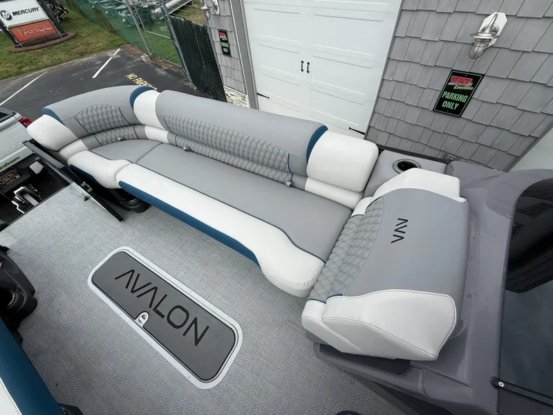 Slide: The Image of 2025 Avalon 2785 Excalibur LTD ELW boat interior with luxurious seating and branding. - 23