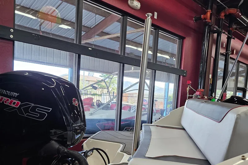 Slide: The Image of 2023 Bayliner Element M19 boat interior with Mercury Pro XS engine in showroom. - 2