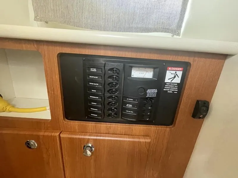 Slide: The Image of Electrical panel inside a 2004 Bayliner 285 boat, featuring switches and a warning label. - 17