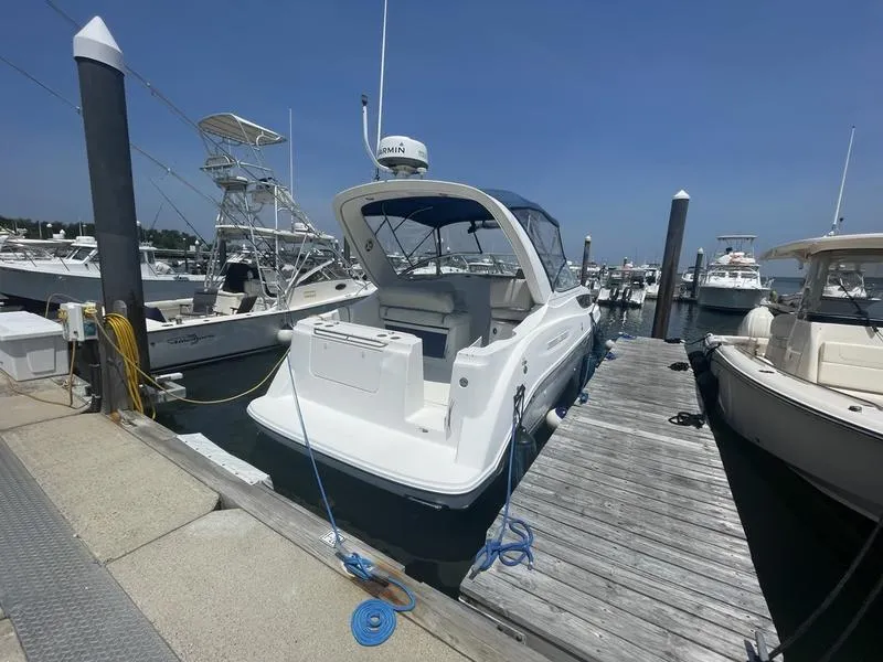 Slide: The Image of 2004 Bayliner 285 boat docked at marina under clear blue sky. - 3