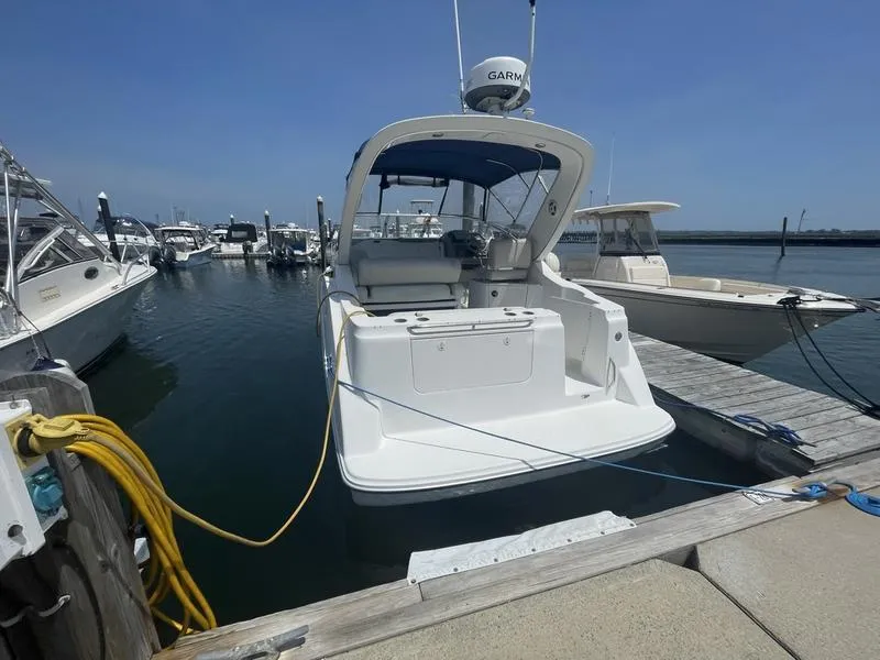Slide: The Image of 2004 Bayliner 285 boat docked at marina, clear sky, calm water. - 6