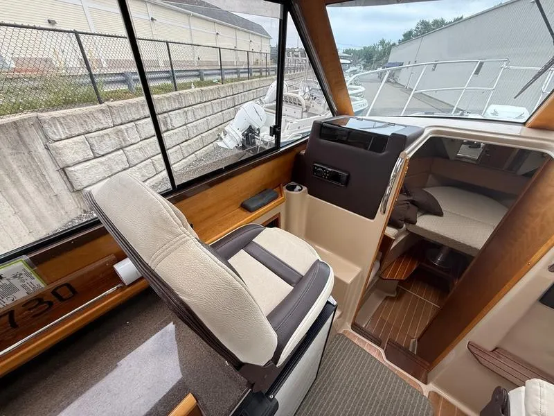 Slide: The Image of Interior of a 2016 Cutwater 288 C boat, featuring helm and cabin area. - 10