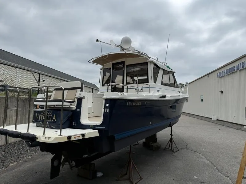 Slide: The Image of 2016 Cutwater 288 C boat on stands, blue and white, in a marina setting. - 11