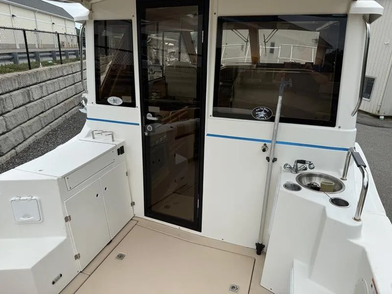 Slide: The Image of 2016 Cutwater 288 C boat deck with door, sink, and storage compartments. - 13