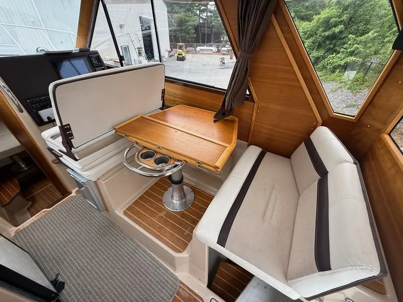 Slide: The Image of Interior of 2016 Cutwater 288 C boat with wooden table and cushioned seating. - 15
