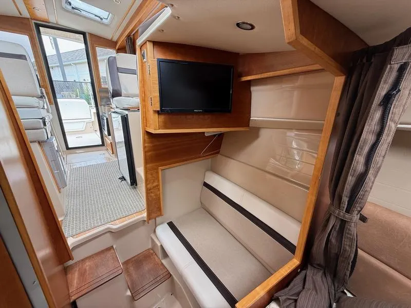 Slide: The Image of Interior of 2016 Cutwater 288 C boat with seating, TV, and wooden accents. - 18