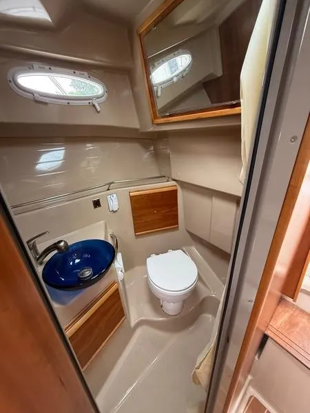 Slide: The Image of 2016 Cutwater 288 C boat bathroom with blue sink and wooden accents. - 19