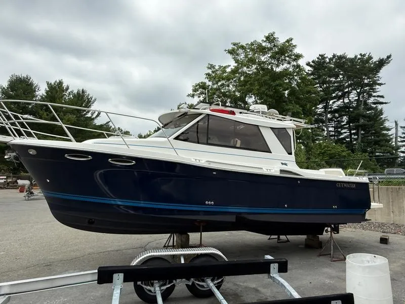 Slide: The Image of 2016 Cutwater 288 C boat on trailer, parked outdoors with trees in background. - 4