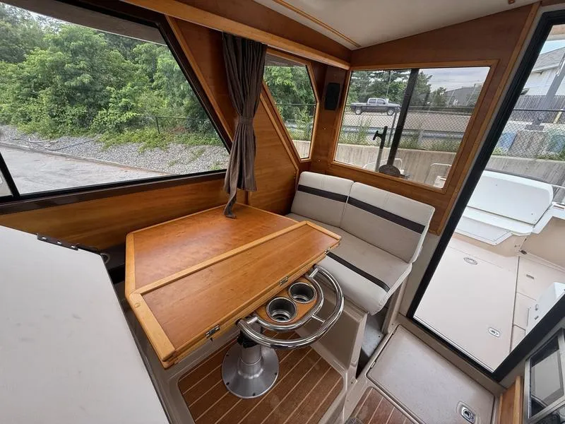 Slide: The Image of Interior of a 2016 Cutwater 288 C boat with wooden table and seating. - 7