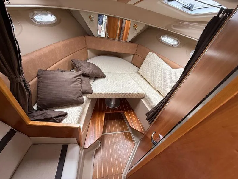 Slide: The Image of 2016 Cutwater 288 C cabin interior with cozy seating and wooden flooring. - 8