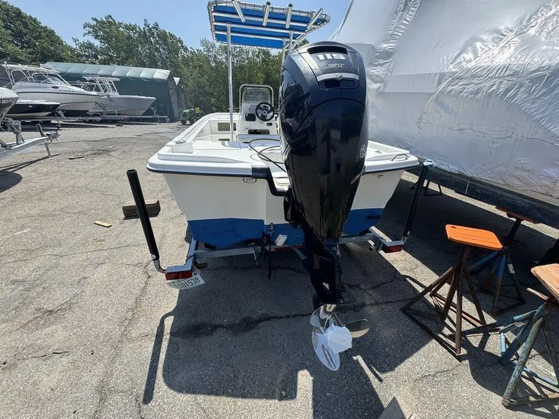 Slide: The Image of 2017 Mako 21 Pro Skiff CC boat with outboard motor in a marina setting. - 7