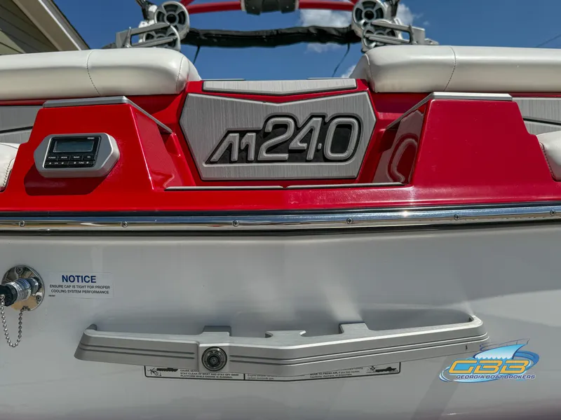 Slide: The Image of 2021 Malibu M240 boat rear view with red accents and logo. - 16