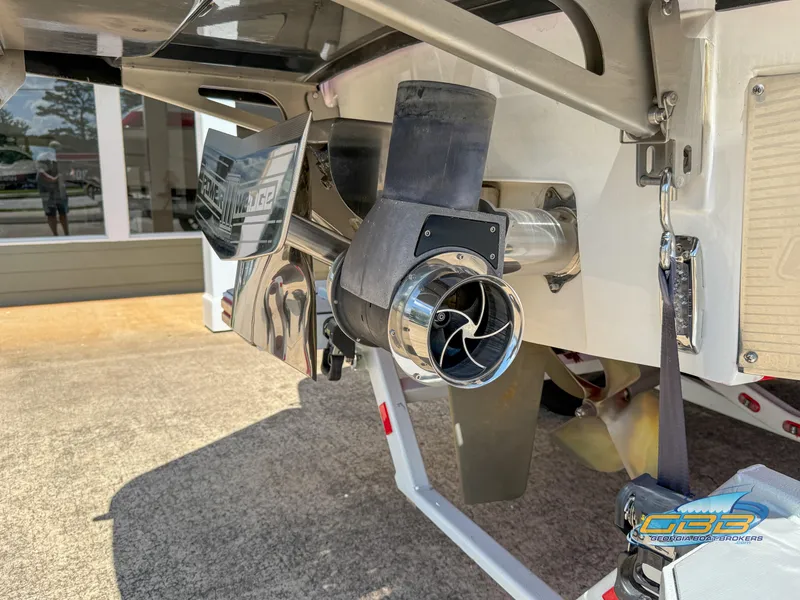 Slide: The Image of 2021 Malibu M240 boat stern with propeller and exhaust system, displayed outdoors. - 19