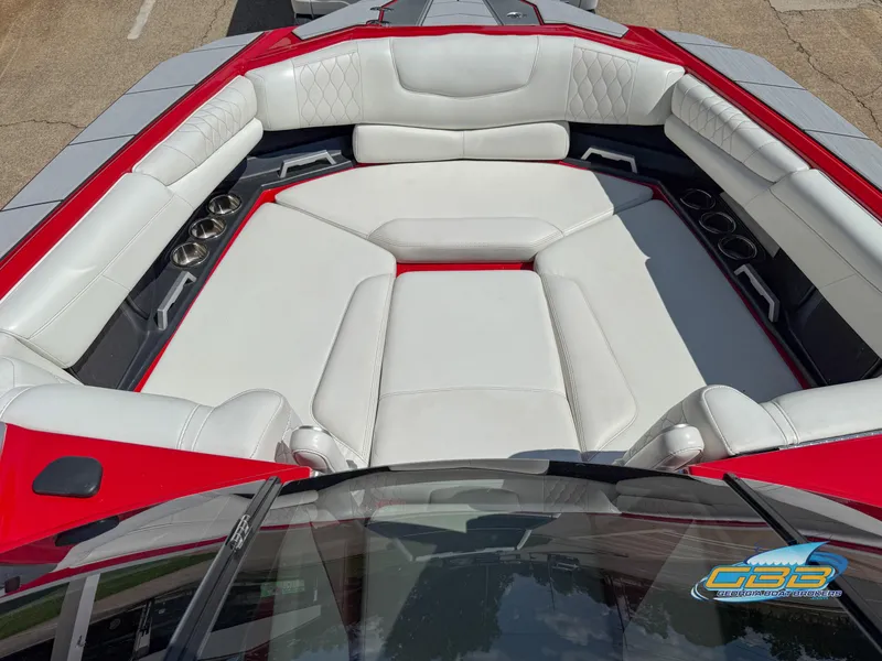 Slide: The Image of 2021 Malibu M240 boat interior with white leather seating and red accents. - 31