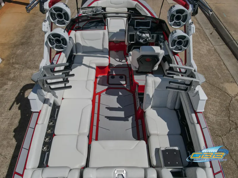 Slide: The Image of 2021 Malibu M240 boat interior with white seating, red accents, and advanced audio system. - 4