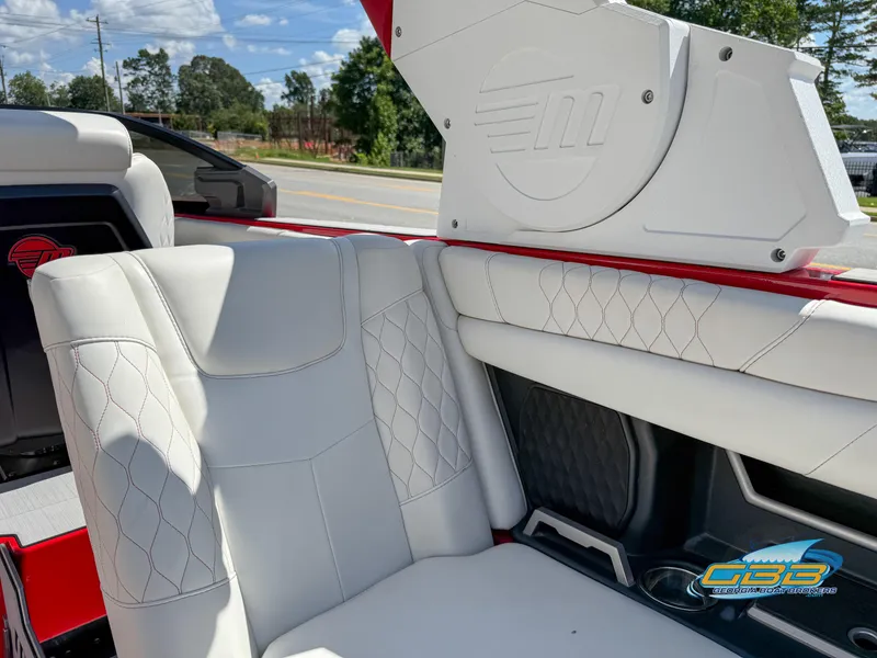 Slide: The Image of 2021 Malibu M240 boat interior with white leather seats and red accents. - 40