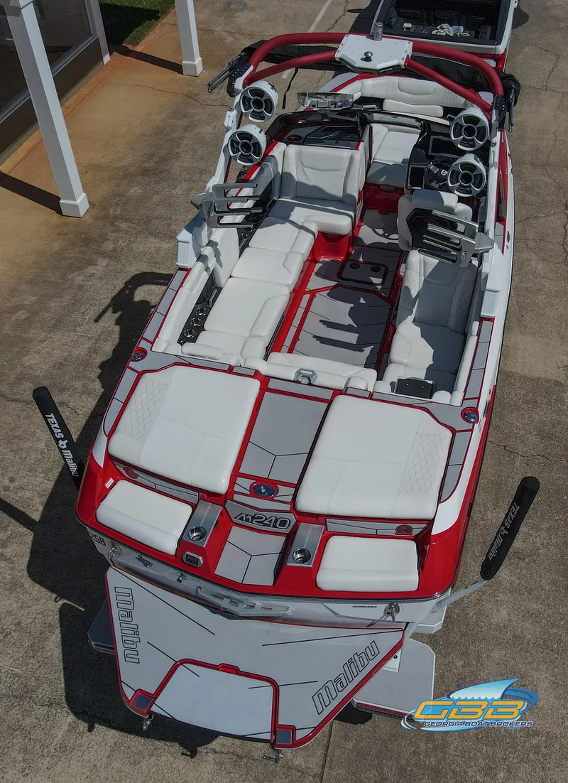 Slide: The Image of 2021 Malibu M240 boat with red and white interior, aerial view. - 8