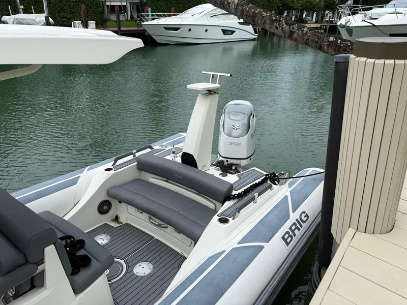 Slide: The Image of 2021 Brig 350 Merc boat docked in a marina, featuring a sleek design and modern seating. - 11