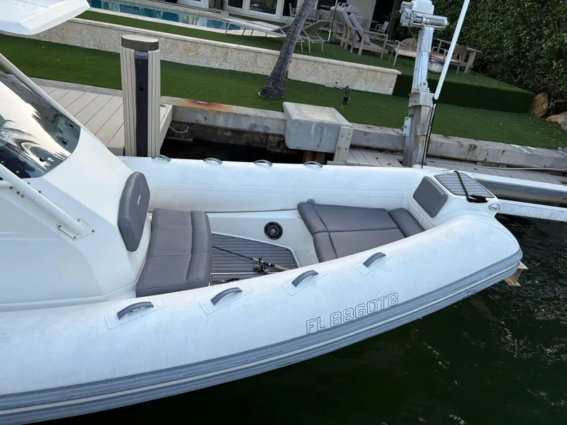 Slide: The Image of 2021 Brig 350 Merc inflatable boat docked by a waterfront patio. - 12