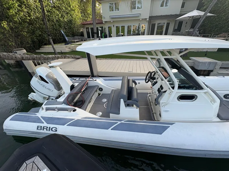 Slide: The Image of 2021 Brig 350 Merc boat docked, featuring Suzuki engine and sleek design. - 14