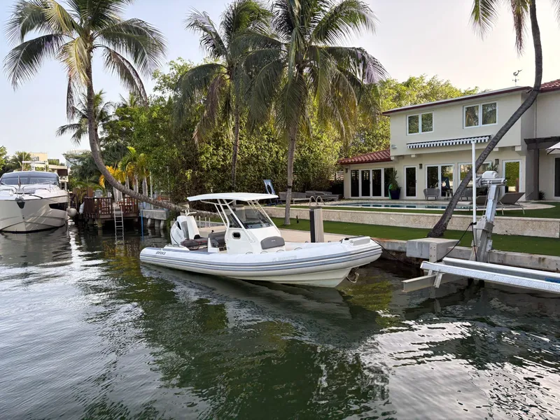 Slide: The Image of 2021 Brig 350 Merc boat docked by a waterfront home with palm trees. - 15