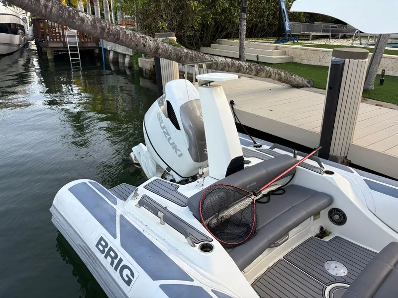 Slide: The Image of 2021 Brig 350 Merc boat with Suzuki engine docked by the water. - 16