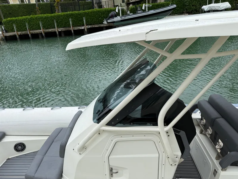 Slide: The Image of 2021 Brig 350 Merc boat with canopy, docked by calm water. - 23