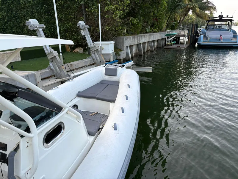 Slide: The Image of 2021 Brig 350 Merc boat docked near lush greenery and calm waters. - 24