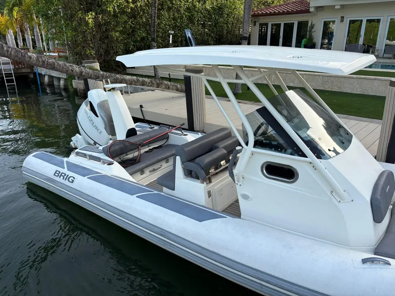 Slide: The Image of 2021 Brig 350 Merc boat docked by waterfront home, featuring sleek design and modern amenities. - 7