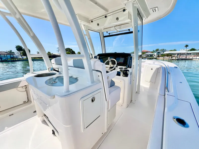 Slide: The Image of 2020 Robalo R302 Center Console boat interior with helm and seating, on calm water. - 14