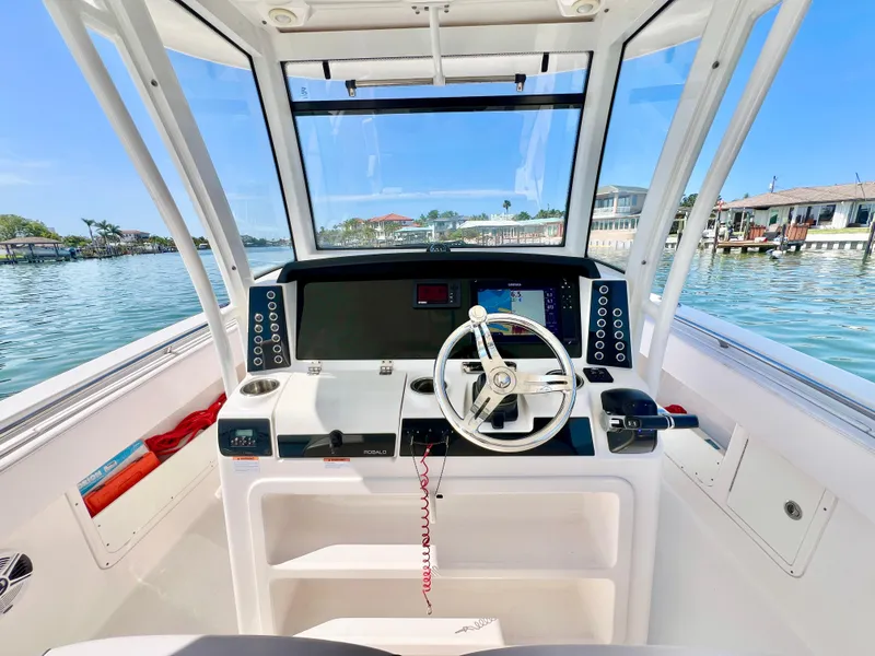 Slide: The Image of 2020 Robalo R302 Center Console helm with modern controls and waterfront view. - 16