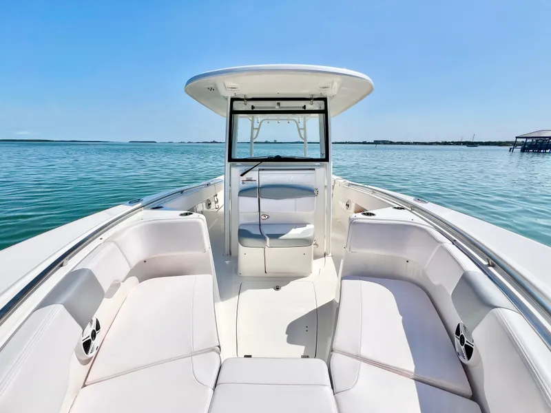 Slide: The Image of 2020 Robalo R302 Center Console boat on calm water, featuring spacious seating and sleek design. - 20