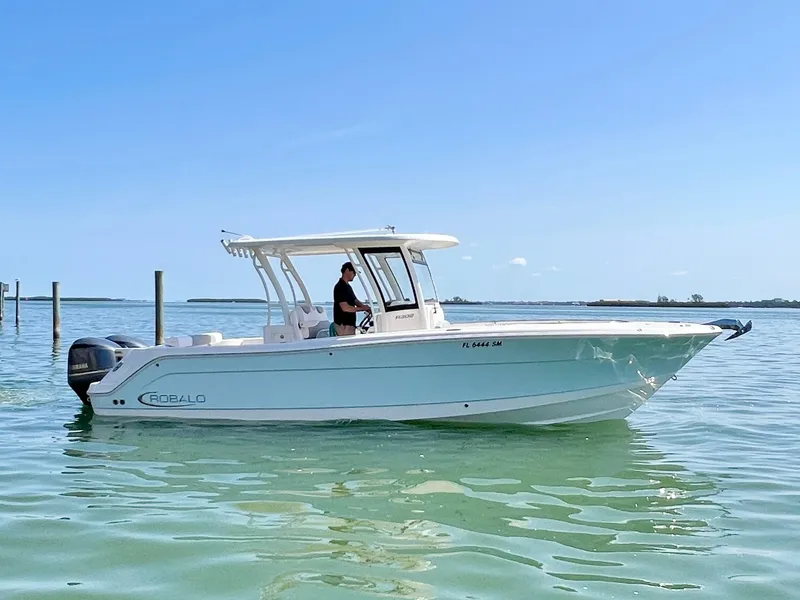 Slide: The Image of 2020 Robalo R302 Center Console boat on calm water, clear sky background. - 3