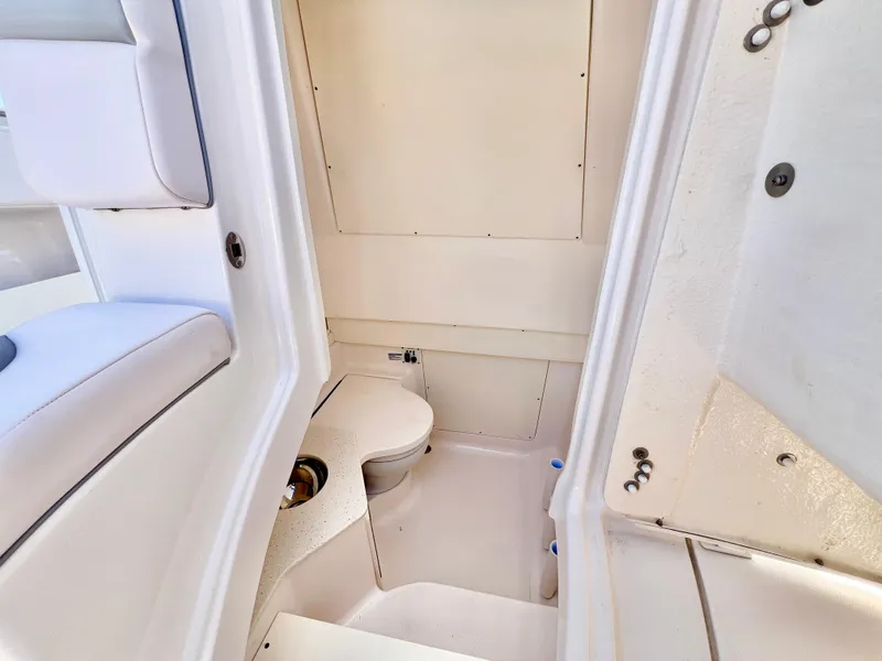Slide: The Image of 2020 Robalo R302 Center Console boat interior with compact marine toilet. - 5