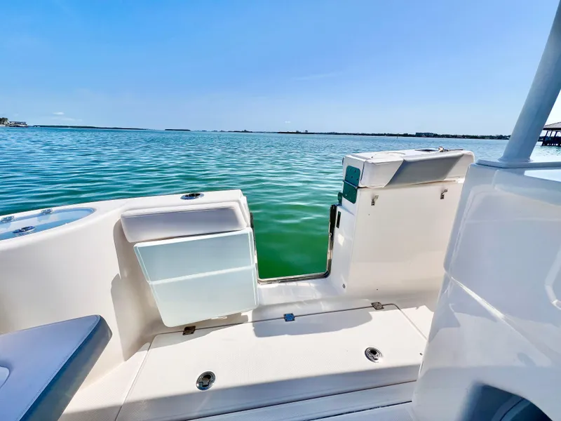 Slide: The Image of 2020 Robalo R302 Center Console boat with open deck, overlooking calm blue waters. - 9