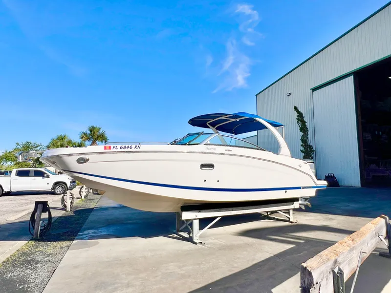The Image of 2018 Four Winns HD270 OB boat on trailer outside a large storage facility. - 0