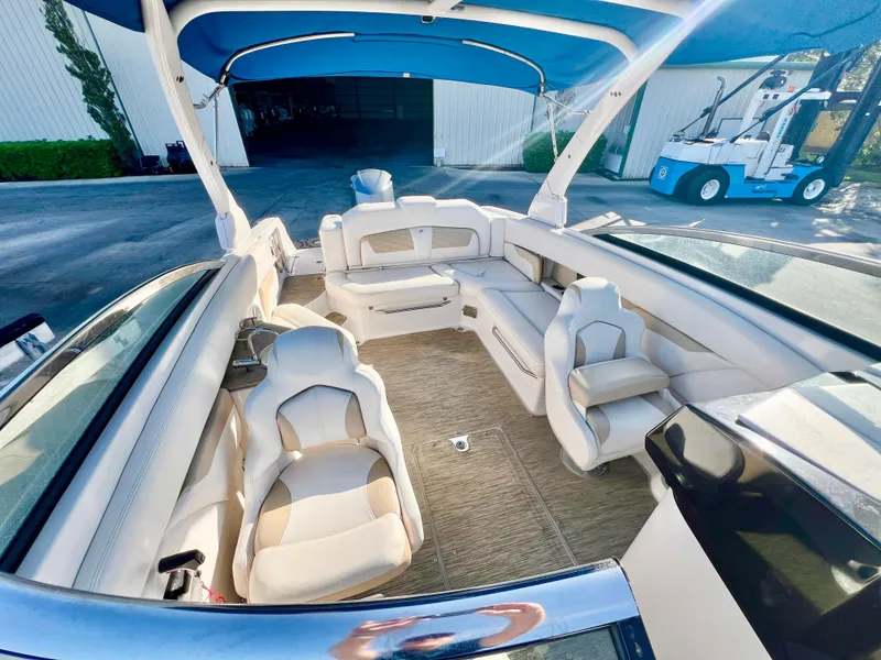 Slide: The Image of 2018 Four Winns HD270 OB boat interior with spacious seating and blue canopy. - 13
