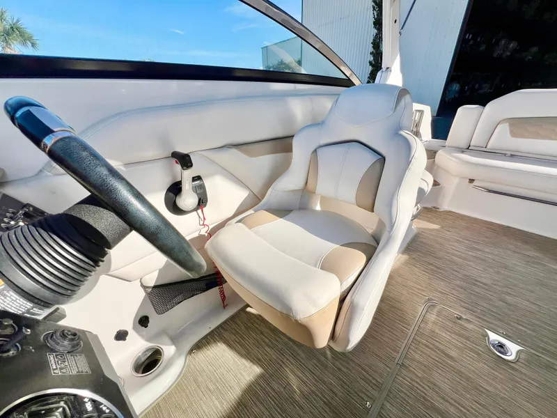 Slide: The Image of 2018 Four Winns HD270 OB boat interior with steering wheel and plush seating. - 16