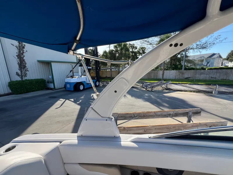 Slide: The Image of 2018 Four Winns HD270 OB boat interior with blue canopy and dockside view. - 21