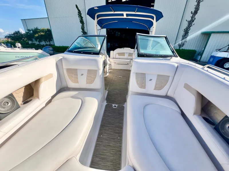 Slide: The Image of 2018 Four Winns HD270 OB boat interior with white seating and open deck layout. - 24