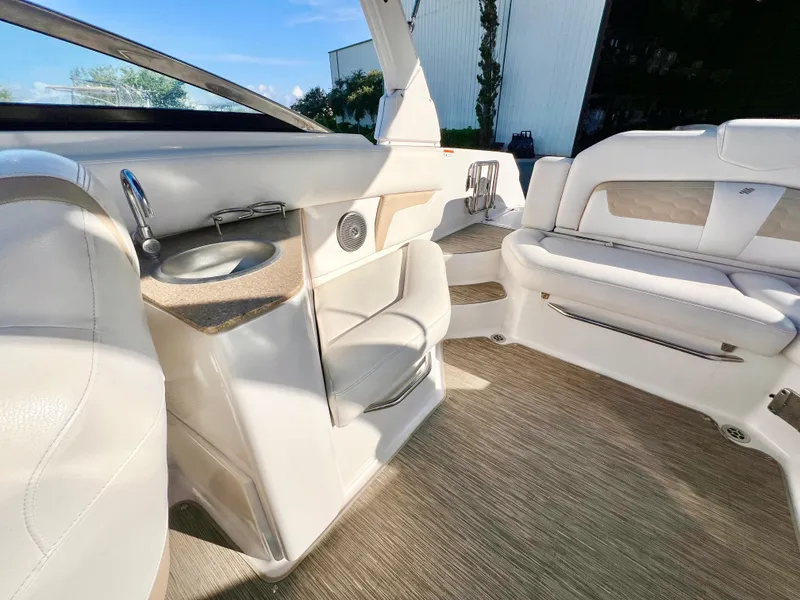 Slide: The Image of 2018 Four Winns HD270 OB boat interior with white seating and built-in cup holders. - 8