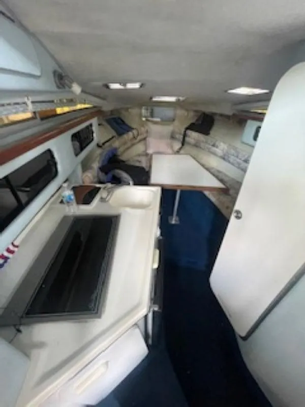 Slide: The Image of Interior of 1989 Sea Ray 250 DA boat with kitchenette and seating area. - 13