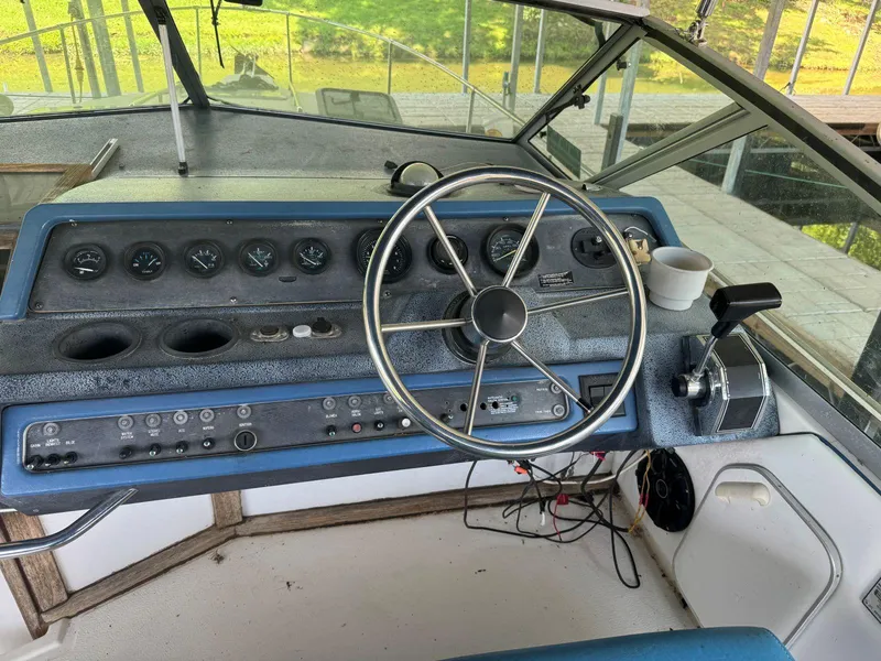 Slide: The Image of 1989 Sea Ray 250 DA boat dashboard with steering wheel and control panel. - 6