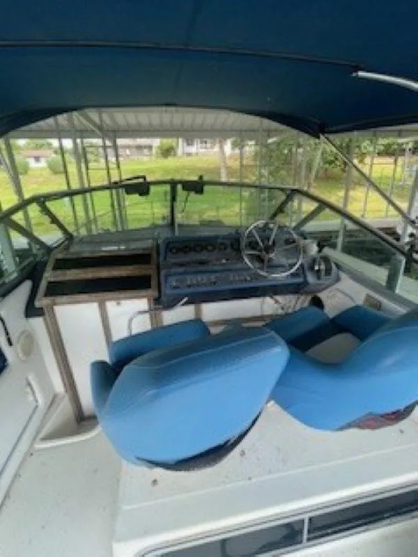 Slide: The Image of 1989 Sea Ray 250 DA boat cockpit with blue seats and steering wheel. - 7