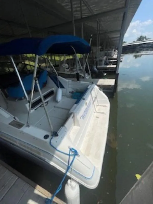 Slide: The Image of 1989 Sea Ray 250 DA boat docked under a covered marina. - 8