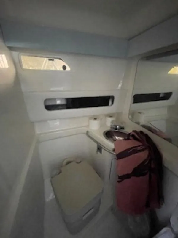 Slide: The Image of 1989 Sea Ray 250 DA boat bathroom with sink, mirror, and storage. - 9